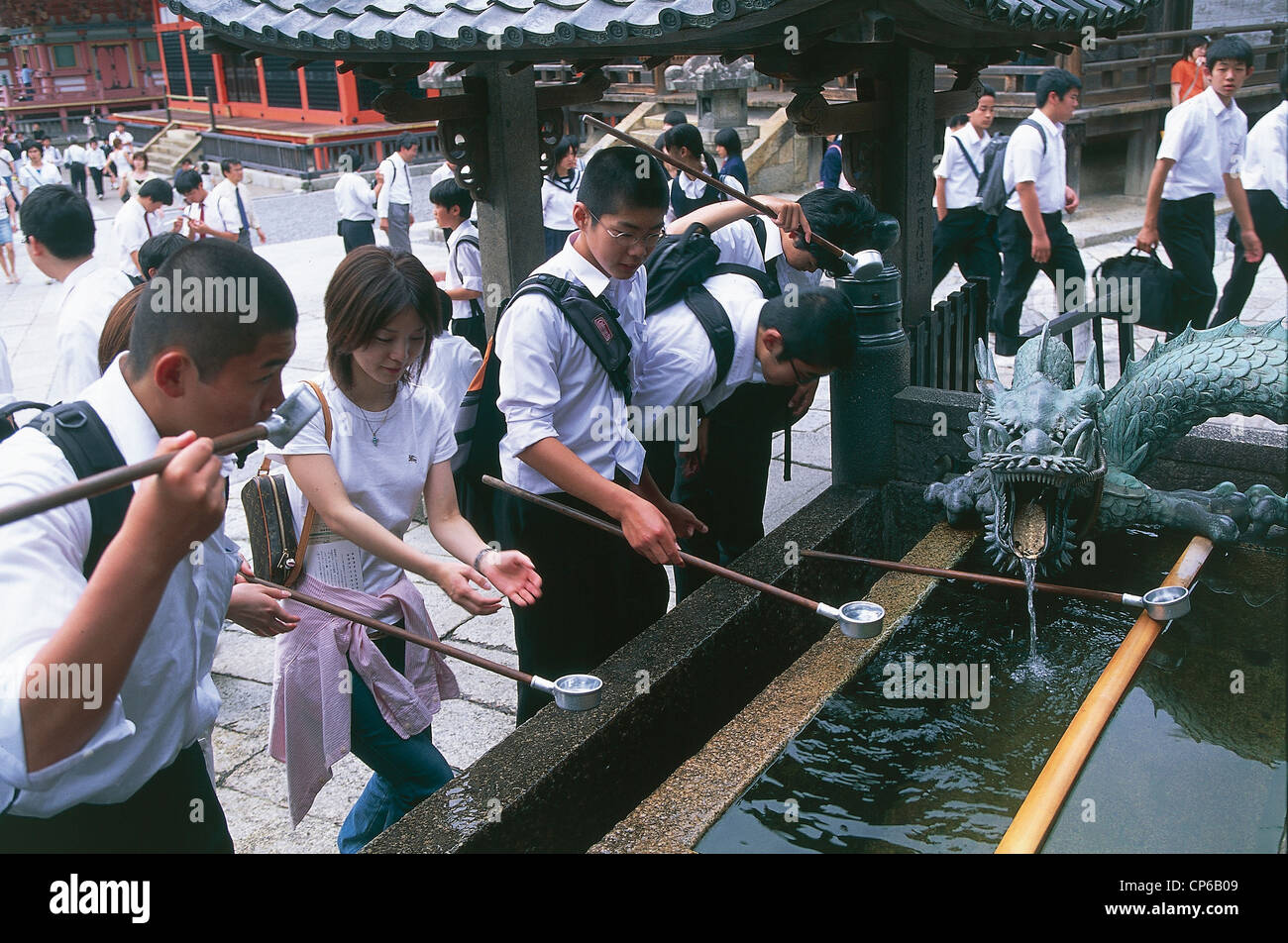JAPAN, Kansai, Kyoto. STUDENTS DRINK WATER FROM THE SOURCE OF THE HOLY