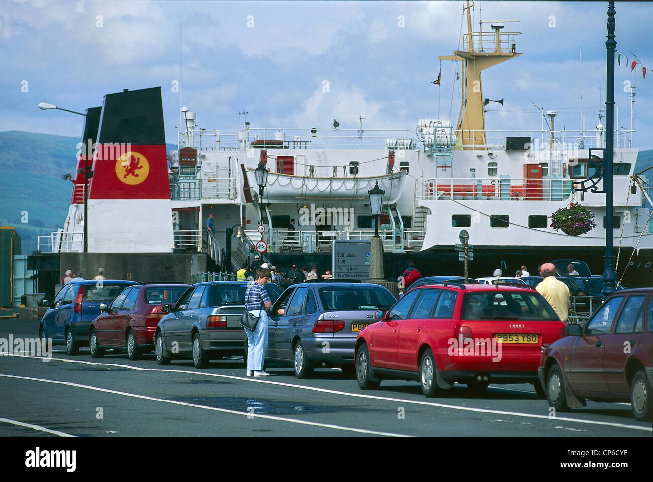 United Kingdom - Scotland - Isle of Bute - Rothesay, the port with the row of cars for boarding the ferry Stock Photo
