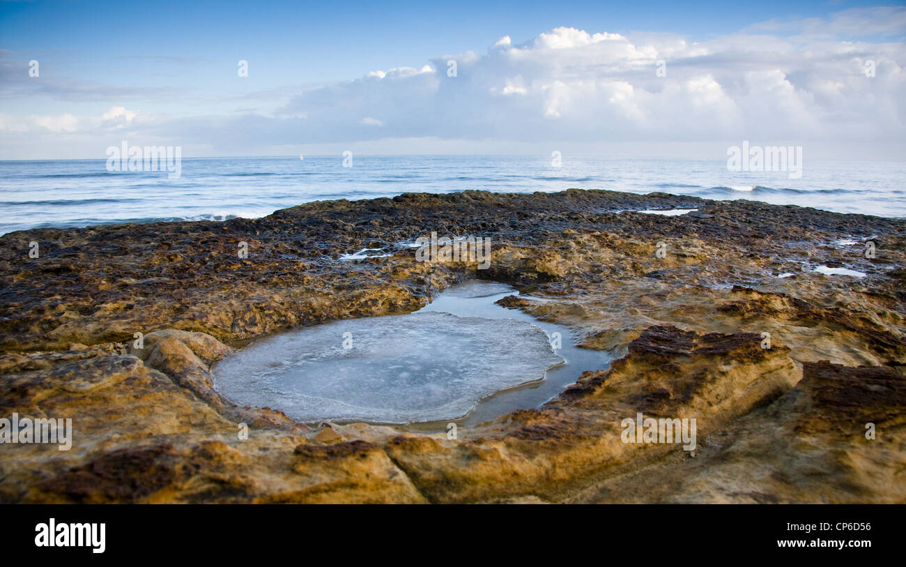 Ice filled dinosaur footprint overlooking North Sea, South Bay, Scarborough, North Yorkshire, England, UK Stock Photo