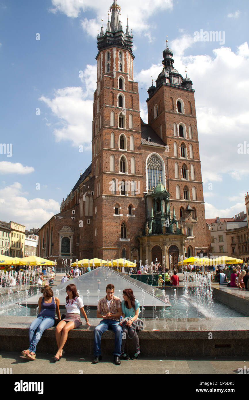 People sitting next to  fountain in the Main market square in Krakow, Poland Stock Photo