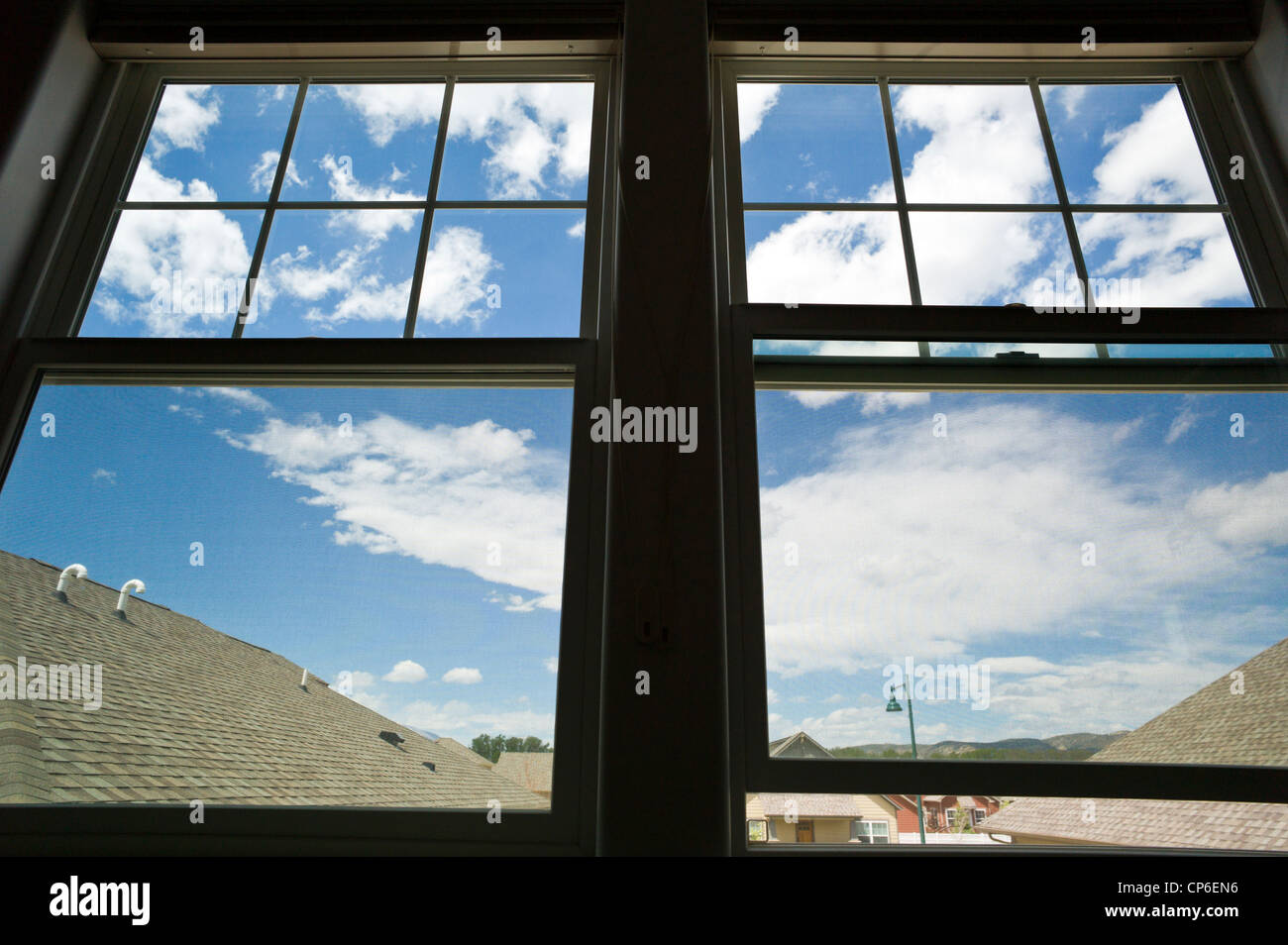 View of sky and clouds through the windows of a home office. Stock Photo