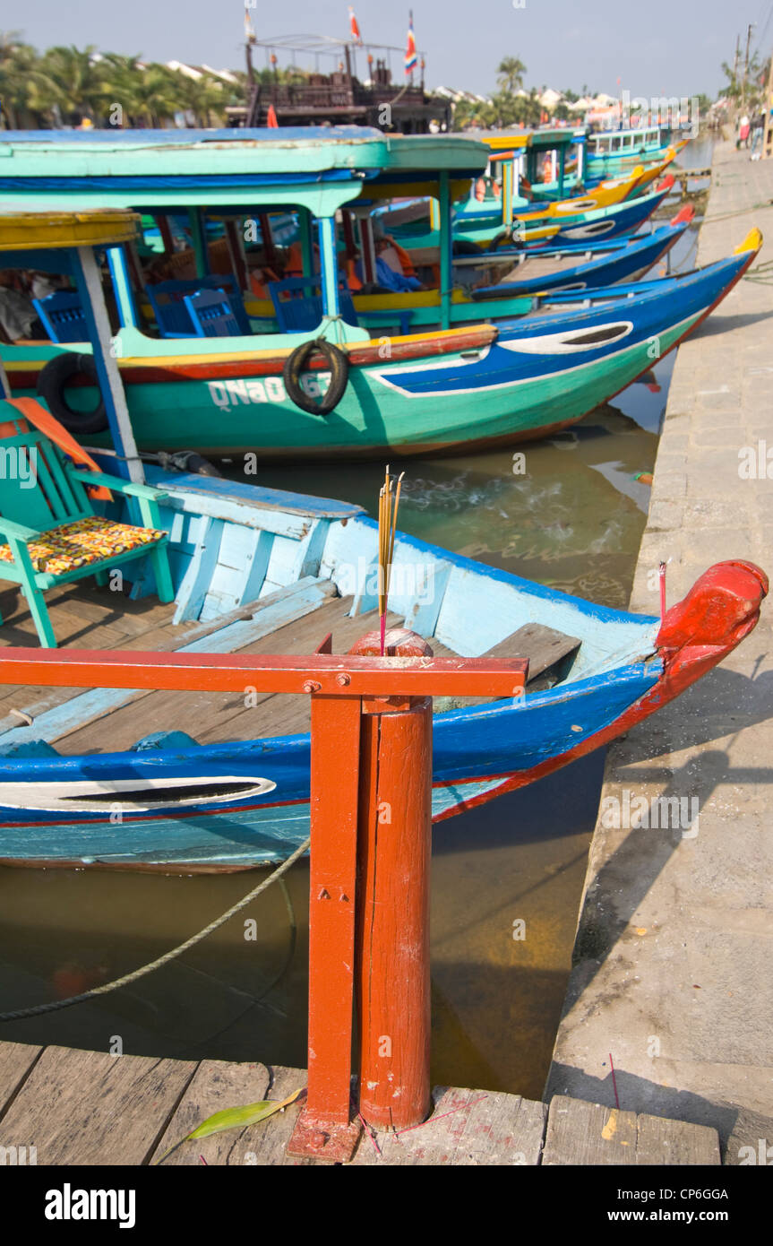 Horizontal close up of eyes painted on the bows of tourist boats and incense sticks burning for good luck in Hoi An, Vietnam. Stock Photo