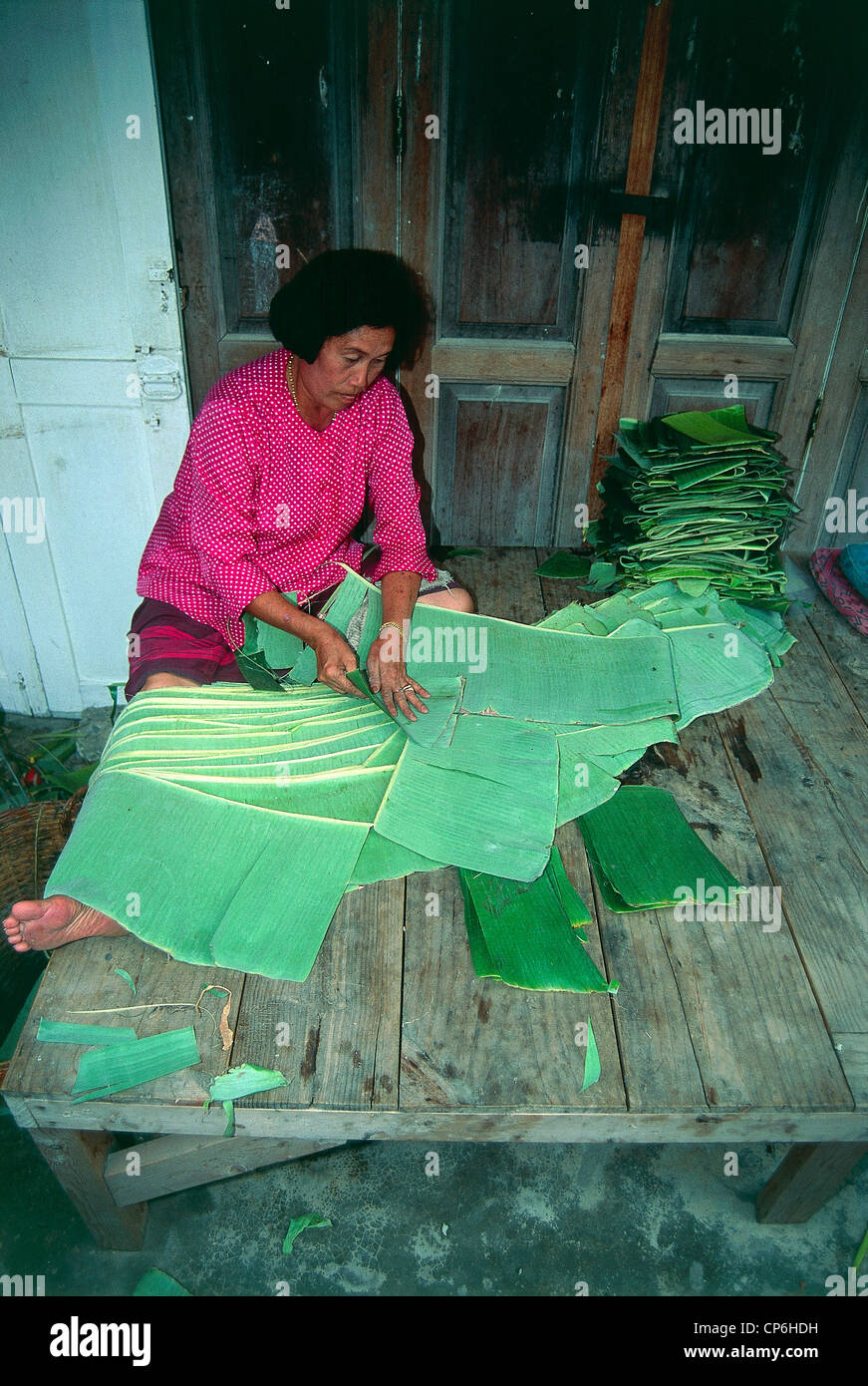 Thailand - Province of Chiang Mai - Chiang Mai. A woman cuts banana leaves, then used for cooking Stock Photo