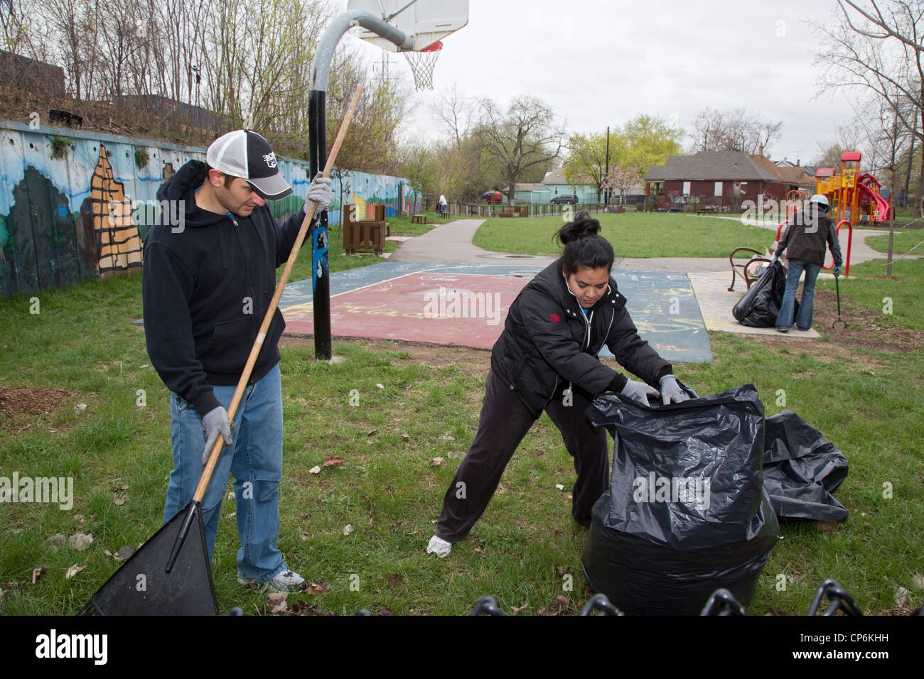 Detroit, Michigan - Volunteers from Chrysler Corp. clean trash and leaves from a park. Stock Photo