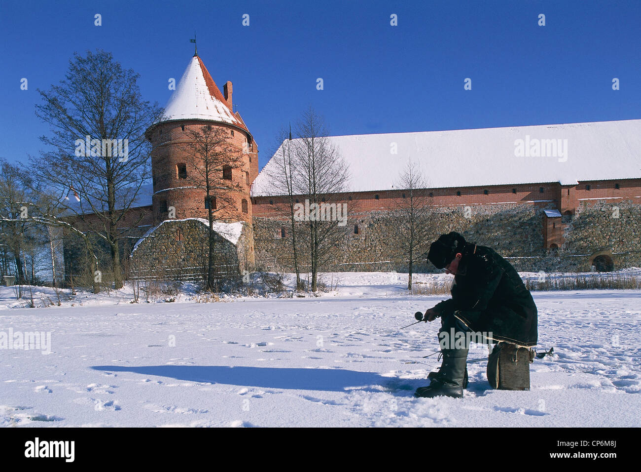 Lithuania - Trakai. Fisherman on Lake Galve frozen and the castle Stock Photo