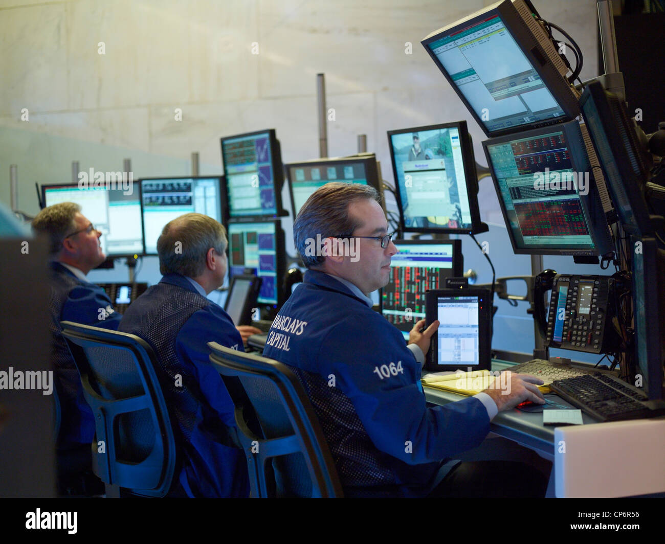 Traders work in front of computers on the floor of the New York Stock Exchange. Stock Photo