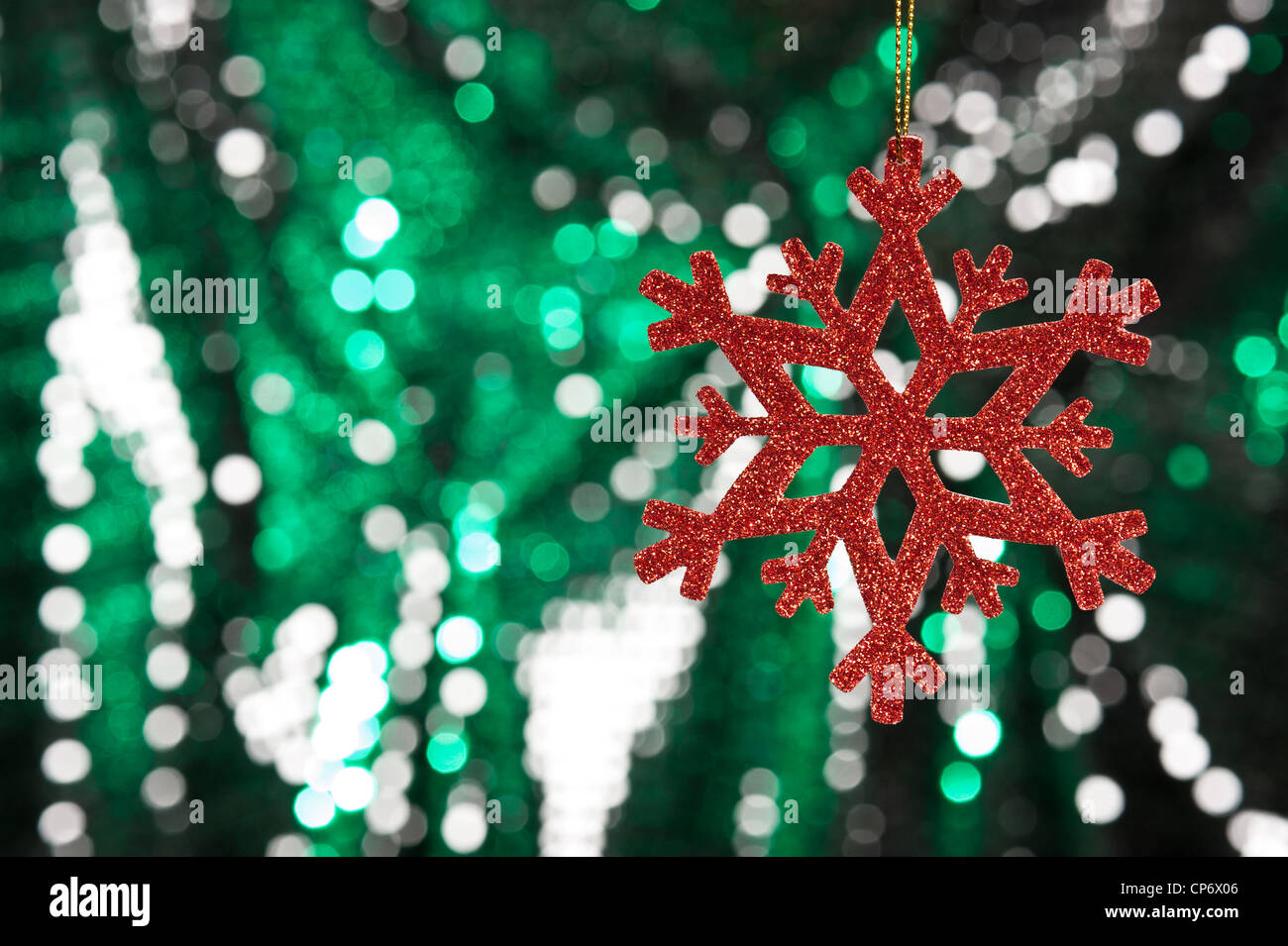 Red snow flake on a green, silver glitter background for Christmas ...