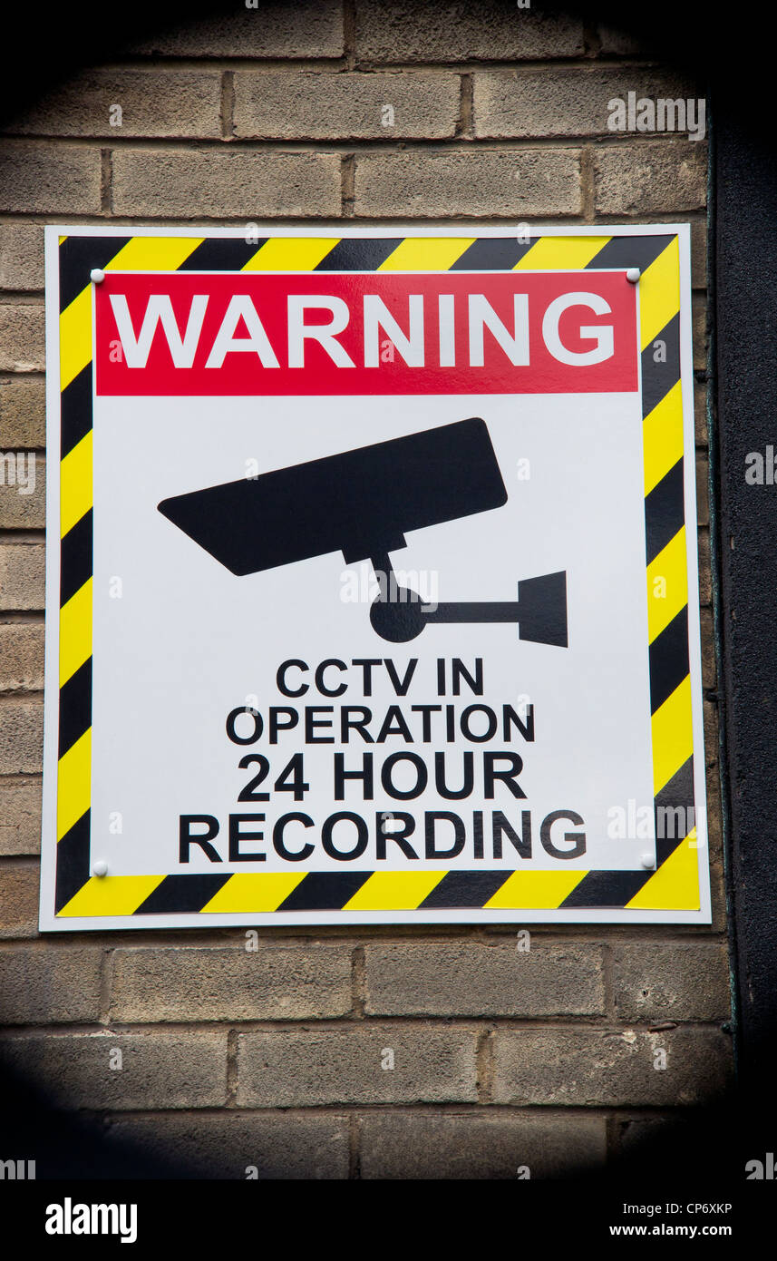 conceptual image illustrating angle of camera lens showing warning sign of close circuit television cameras at business premises Stock Photo
