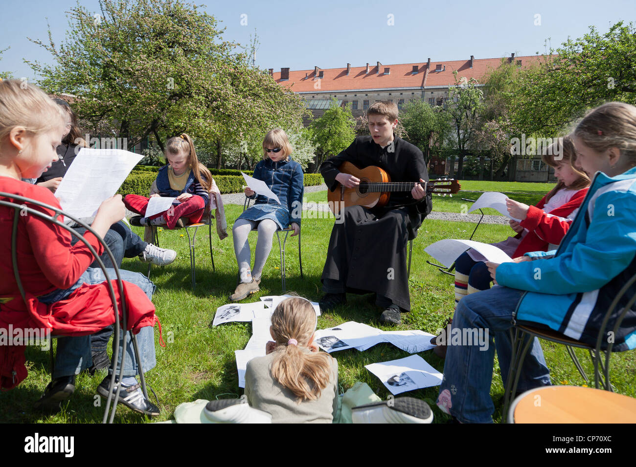 A young priest singing religious songs with a group of girls, Cracow