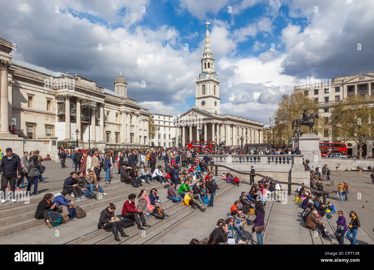 Trafalgar square with tourists relaxing on steps and st. martins-in-the-fields in the background. Stock Photo
