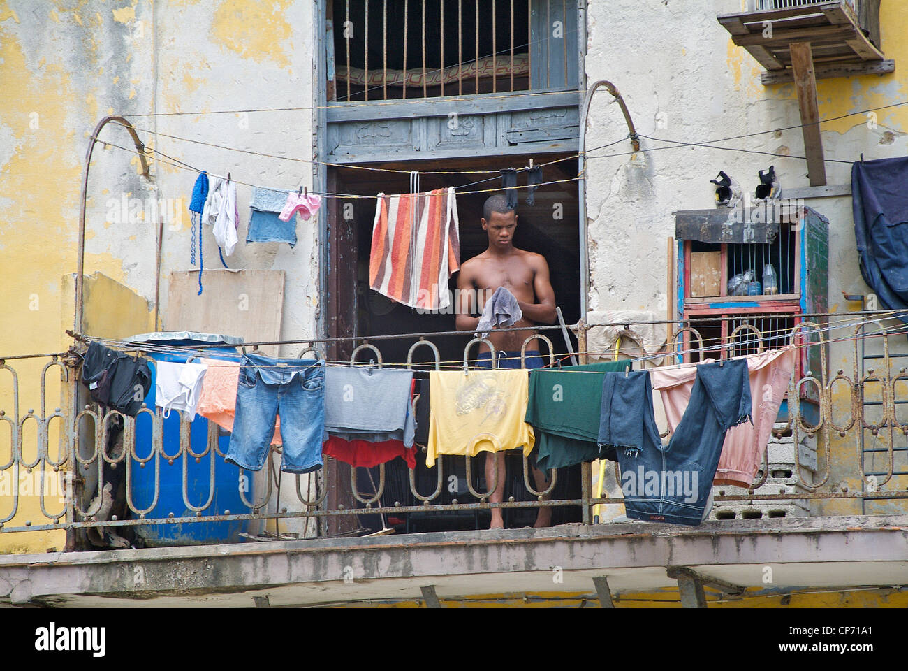 A man hanging out laundry on a balcony, Havana, Cuba Stock Photo