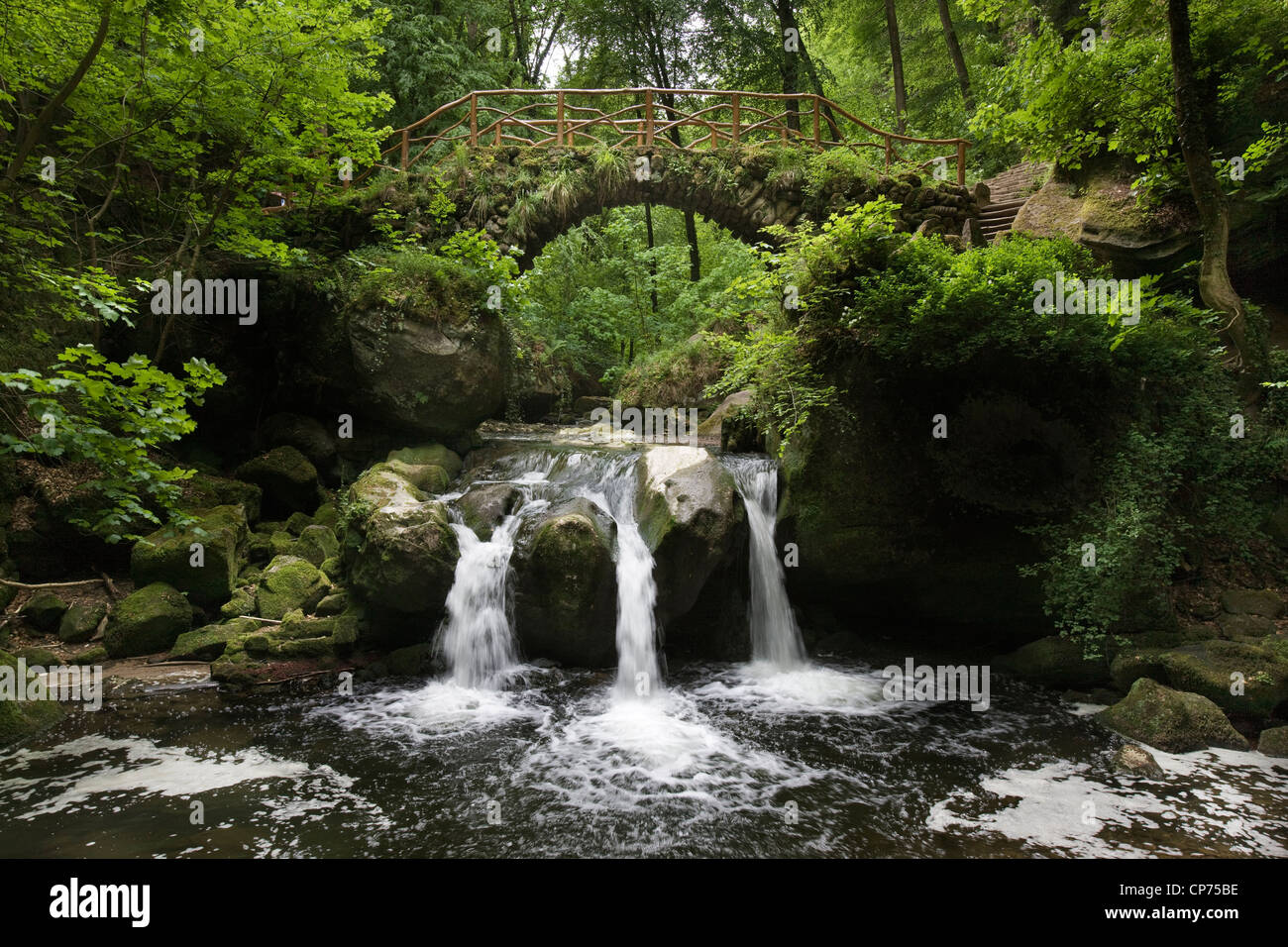 Cascade and old bridge Schiessentümpel over the Black Ernz in Little Switzerland / Mullerthal, Grand Duchy of Luxembourg Stock Photo
