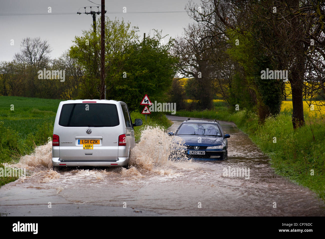 Flooded Road after rain in Essex, England. 3 May 2012. Car drivers attempt to pass along flooded Road Steeple Bumpstead,Essex. Stock Photo