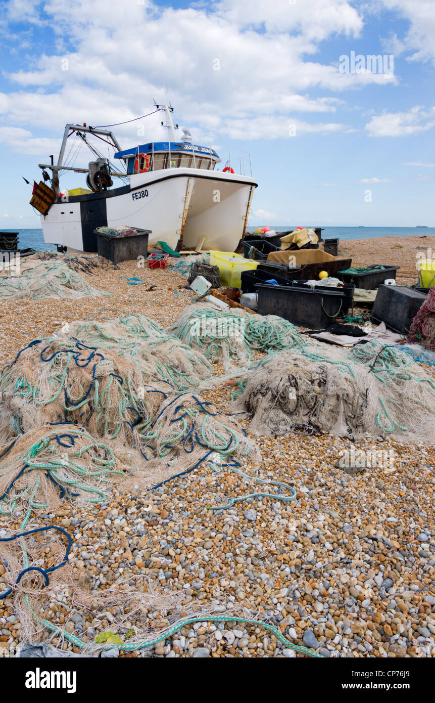 Fishing boat boats shingle beach Dungeness Kent with nets fishing gear ...