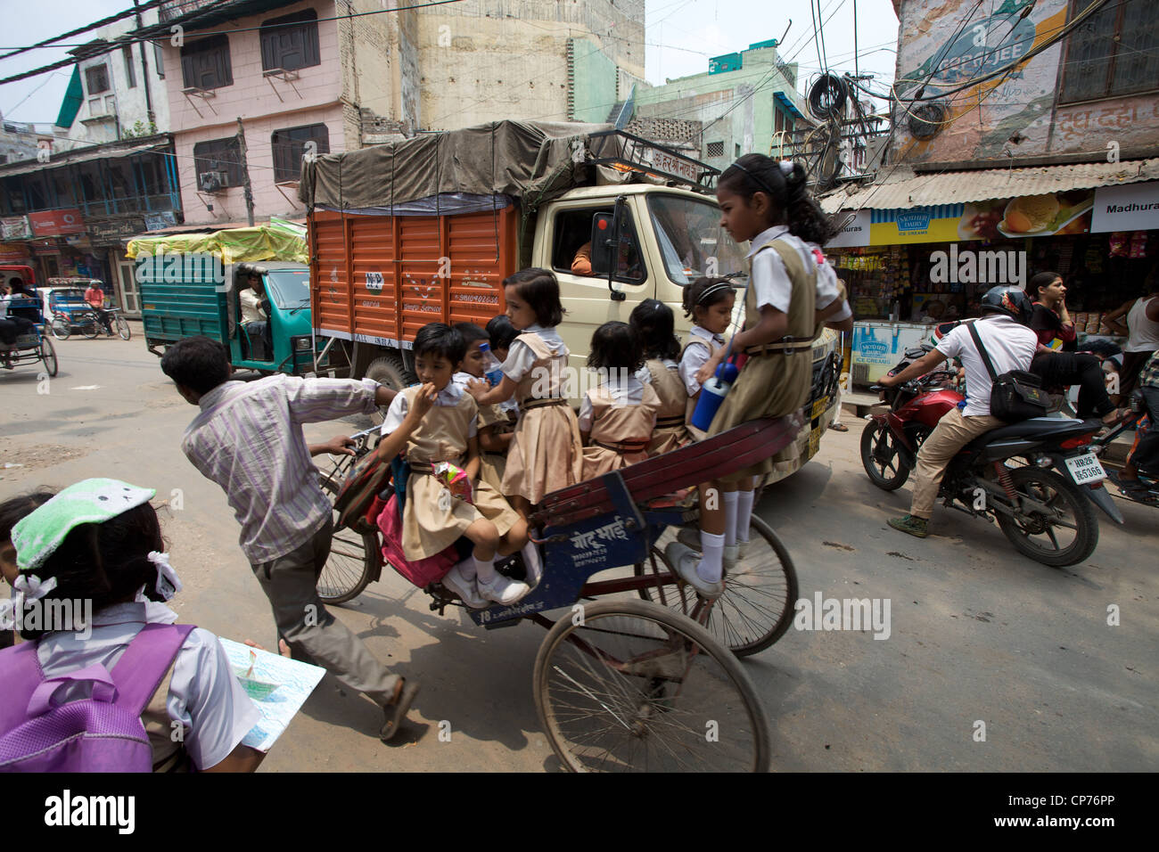 A group of young girls ride to school on a rickshaw, daily life in Old Delhi, India. Stock Photo