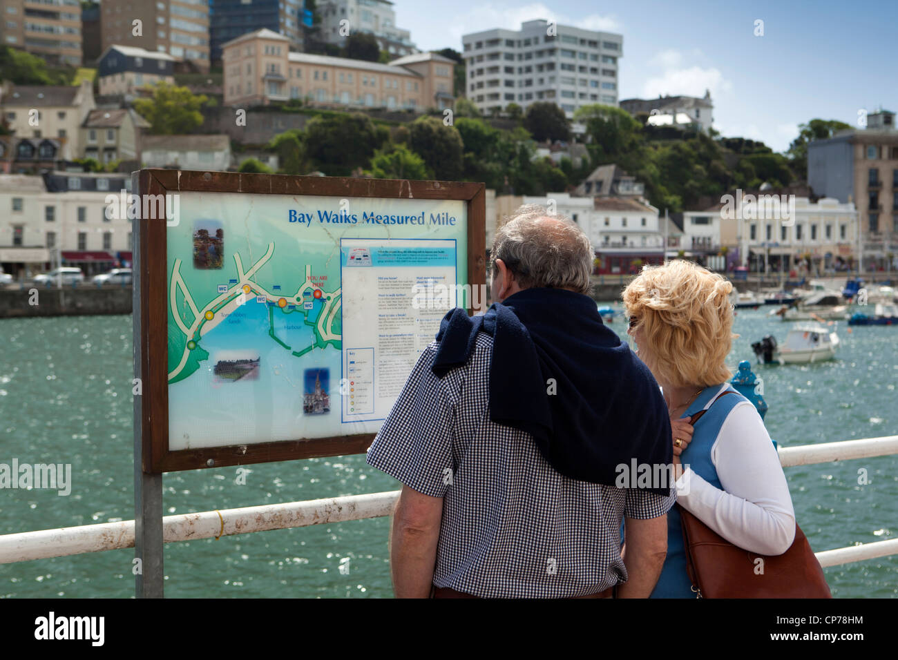 UK, England, Devon, Torquay Harbour, middle aged couple looking at Bay Walks Measured Mile sign Stock Photo