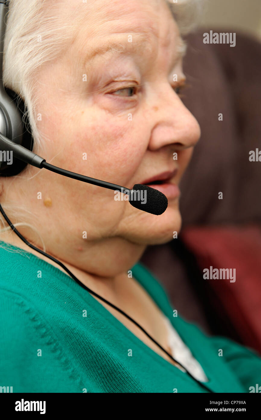 pensioner wearing headphones with a microphone attached england uk Stock Photo
