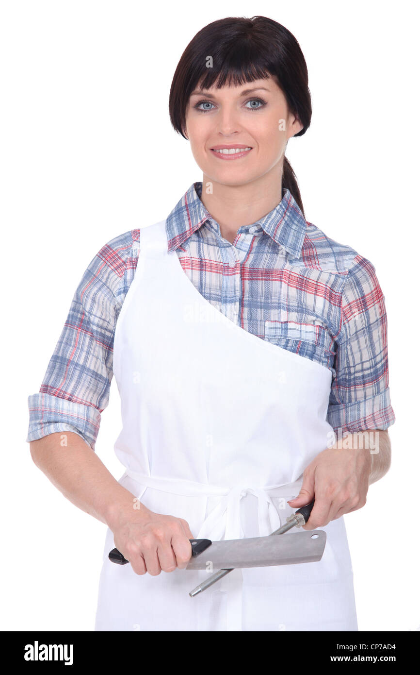 Female chef stood with knife and sharpener Stock Photo Alamy