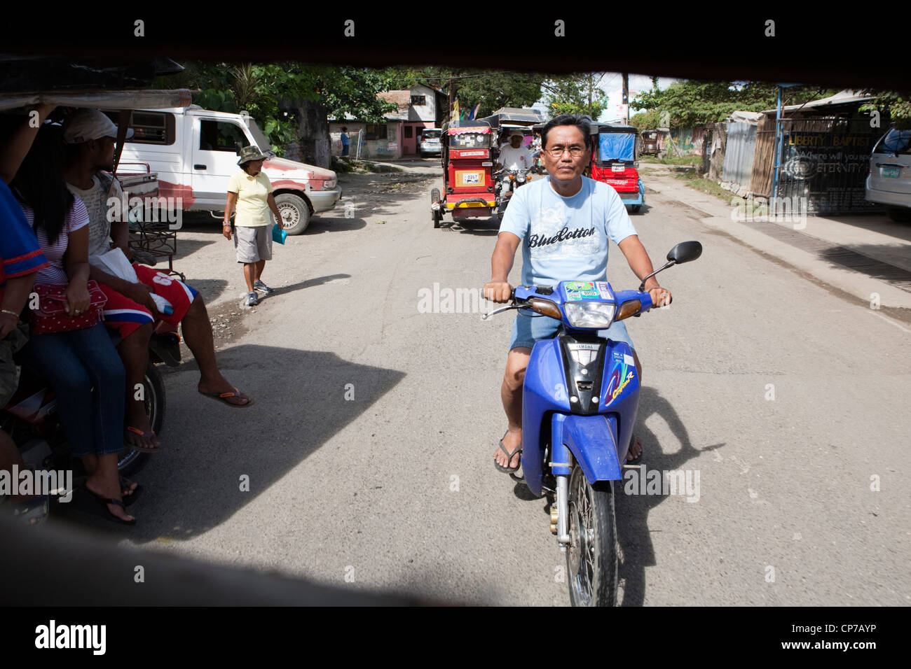 Man riding his motorbike, seen through the window of a tricycle. Lapu-Lapu City, Metro Cebu, Mactan Island, Visayas, Philippines Stock Photo