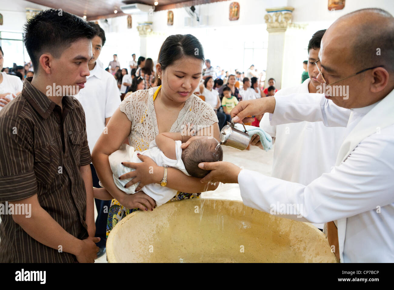 Lapu-Lapu City, Philippines, 26/02/2012: 200-300 babies being baptised in a single 3 hour ceremony at Mactan Air Base Chapel. Stock Photo