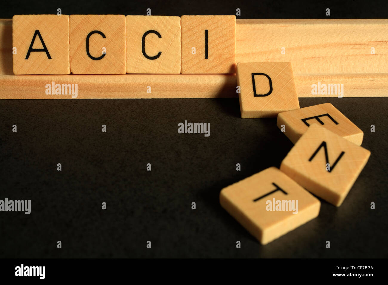 The word 'accident' spelled out in Scrabble alphabet letters, the letters DENT have fallen over Stock Photo