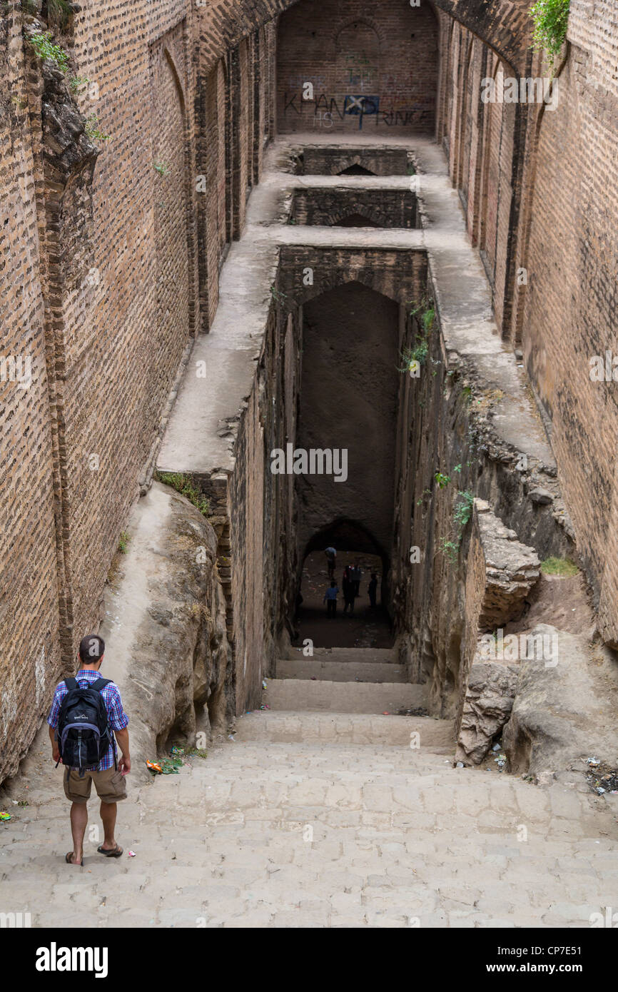 Tourist descending into a step well at Rhotas Fort, Punjab Province, Pakistan Stock Photo