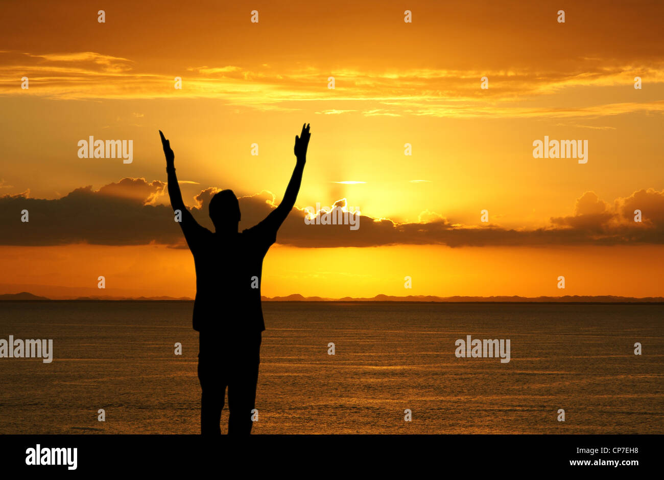 Man with his hands up watching the sun set Stock Photo - Alamy