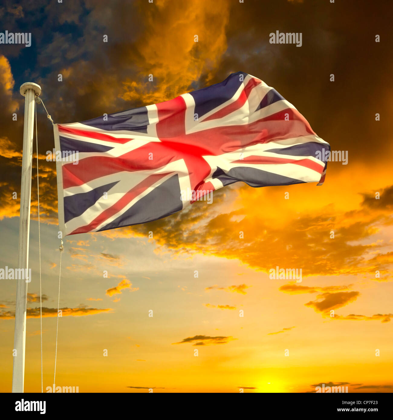 Brexit concept. British Flag (Union Jack) flying from flagpole under dark brooding sky at sunset. Stock Photo
