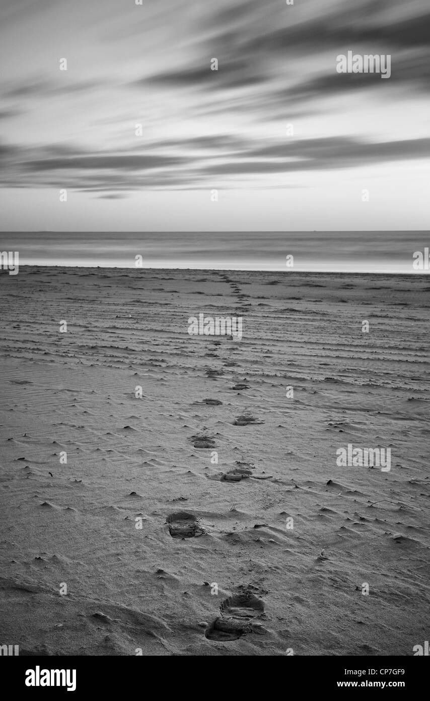 footsteps in the sand in long exposure image Stock Photo - Alamy