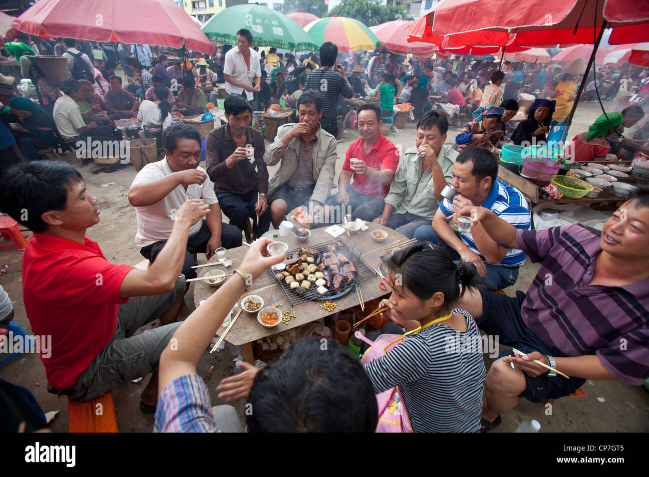 People toasting and eating village market Yuanyang China Asia Stock Photo
