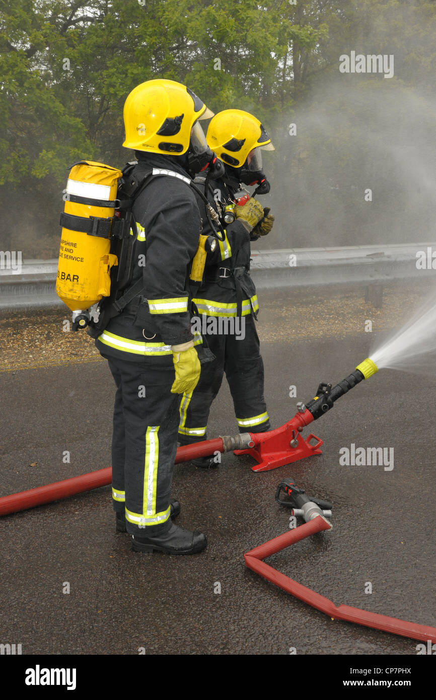Firefighters with cooling spray Stock Photo