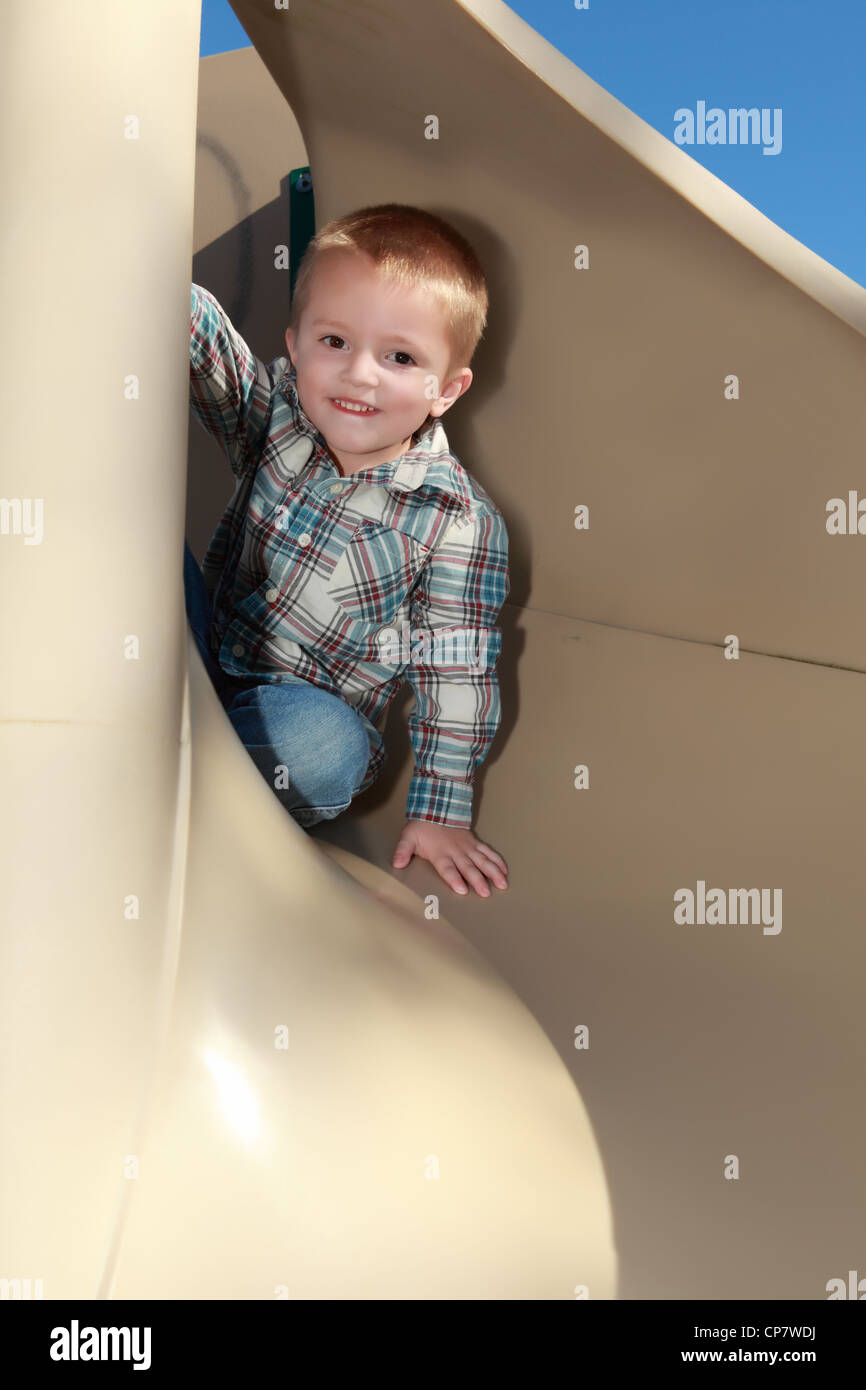 A Child is playing on a slide Stock Photo