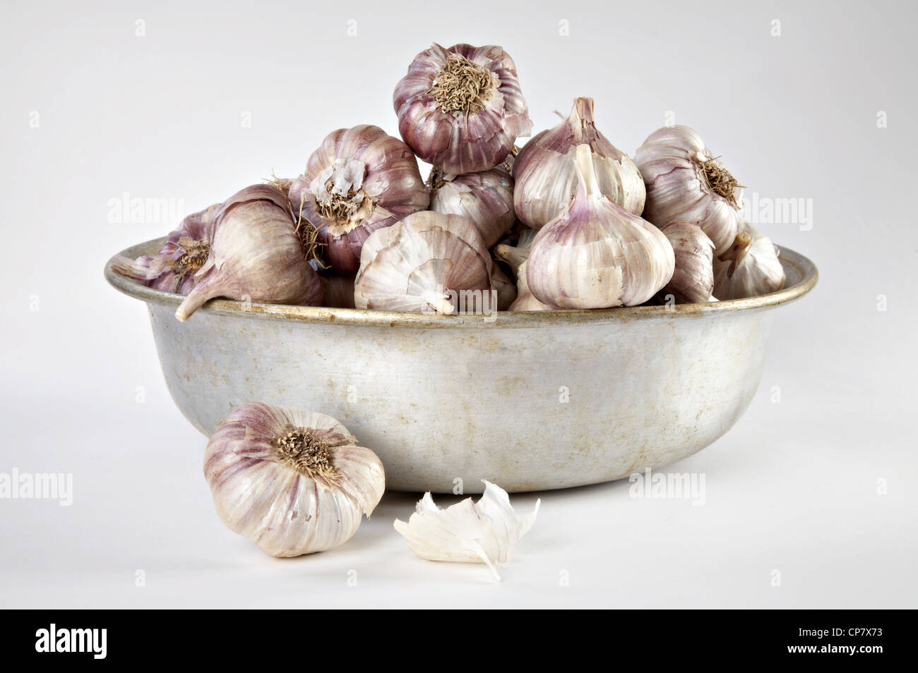 Garlic in a tin bowl on a grey background Stock Photo