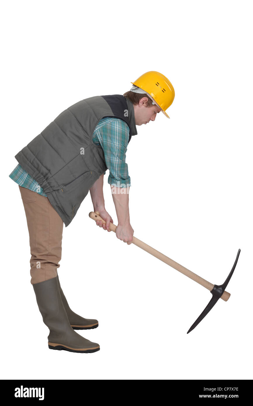 A construction worker digging with a pick axe Stock Photo Alamy