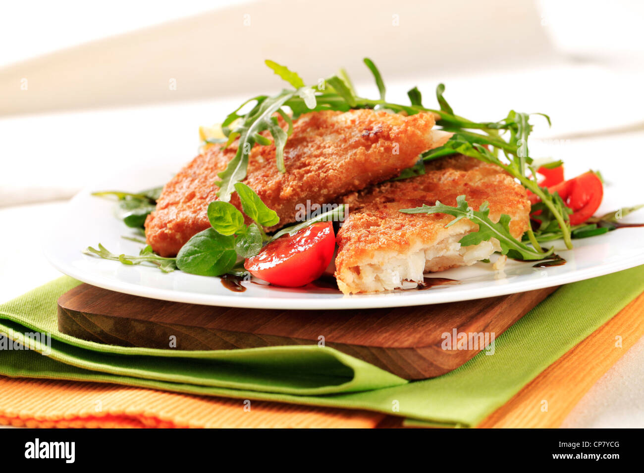 Fried fish on a bed of fresh salad Stock Photo