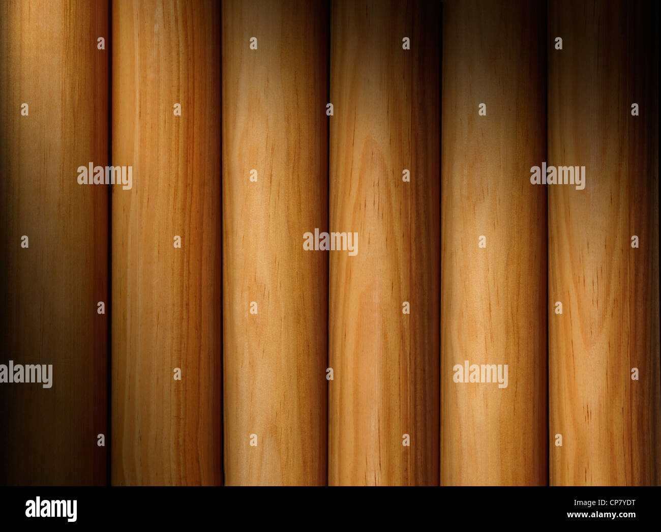 Wooden poles forming a background texture lit diagonally Stock Photo