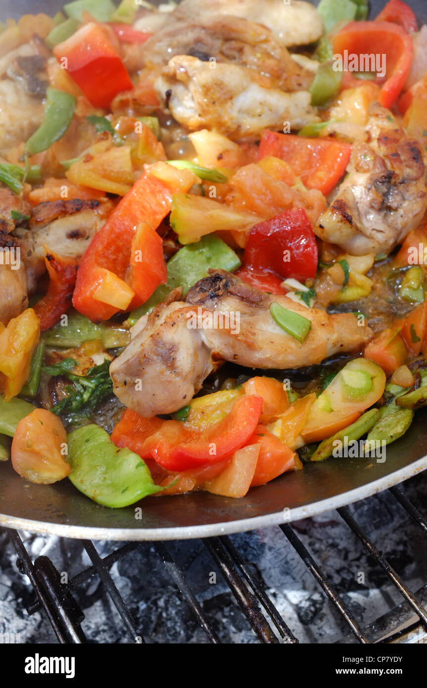 Cooking paella, chicken and vegetables being roasted Stock Photo Alamy