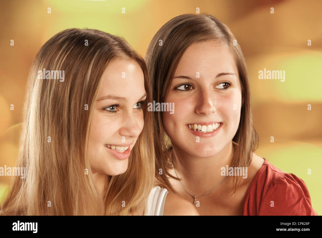 Two pretty young women look smiling to the right. Stock Photo