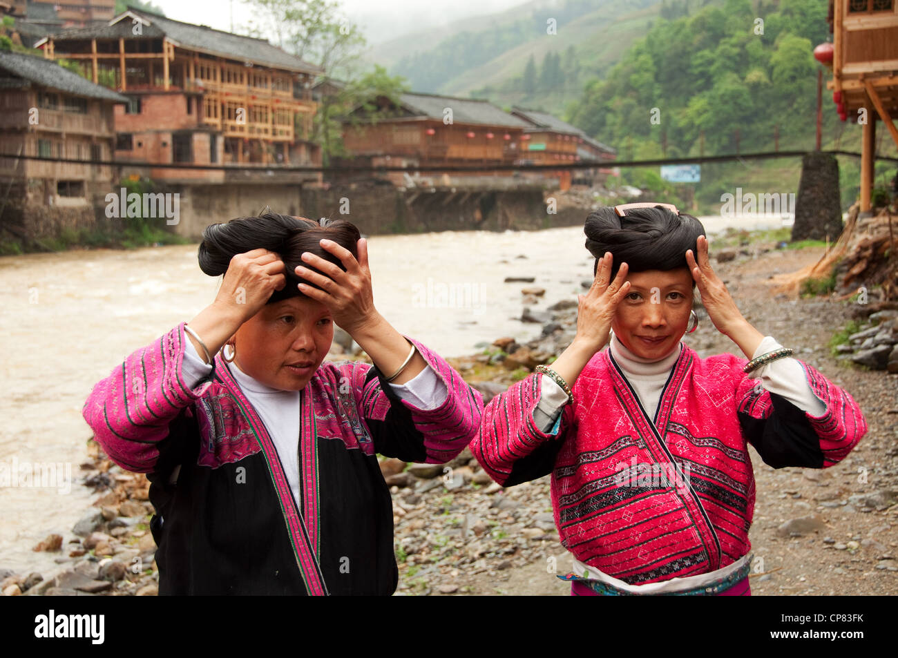 Two Yao women arranging their traditional hairstyles, Huangluo Stock Photo