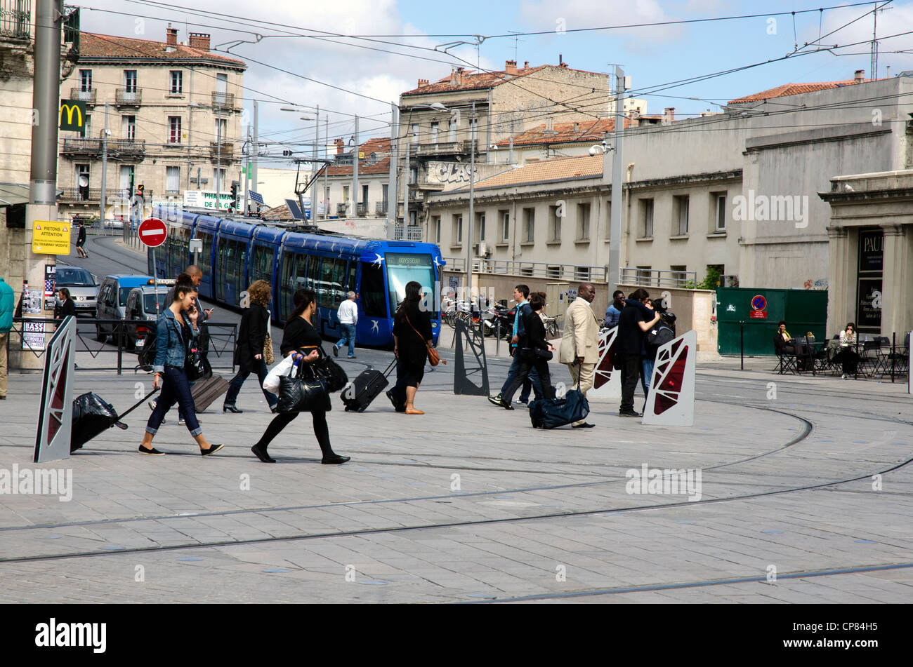 Montpellier city scene. Passengers heading for train station, tram rolling down hill. Stock Photo