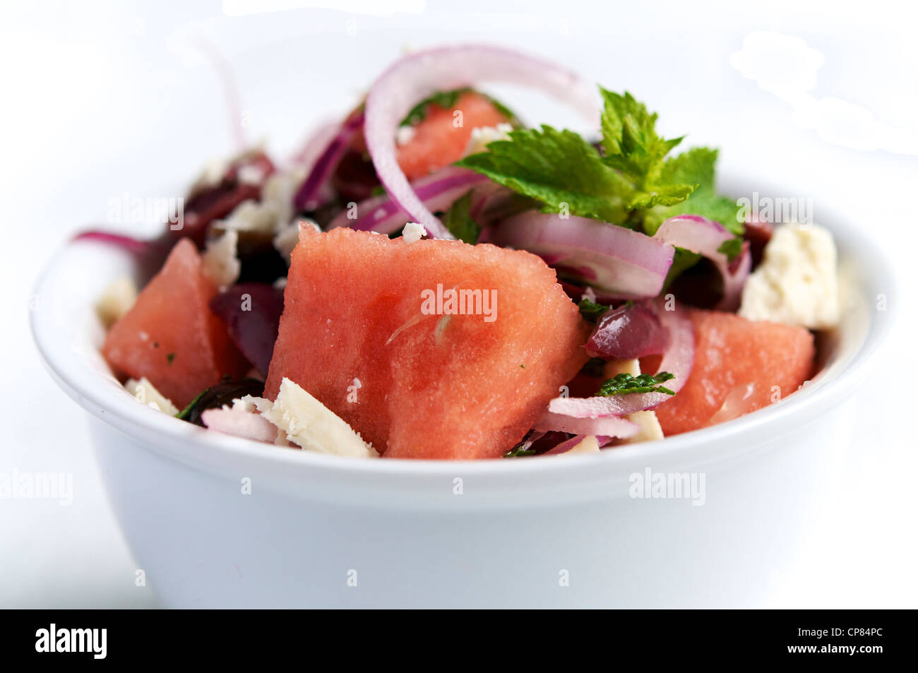 A refreshing summer time salad with watermelon, black olives, red onion and soy cheese. Stock Photo