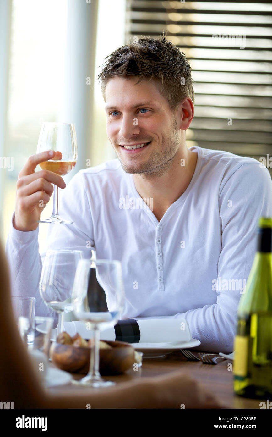 Portrait of a handsome guy holding a glass of wine at a restaurant