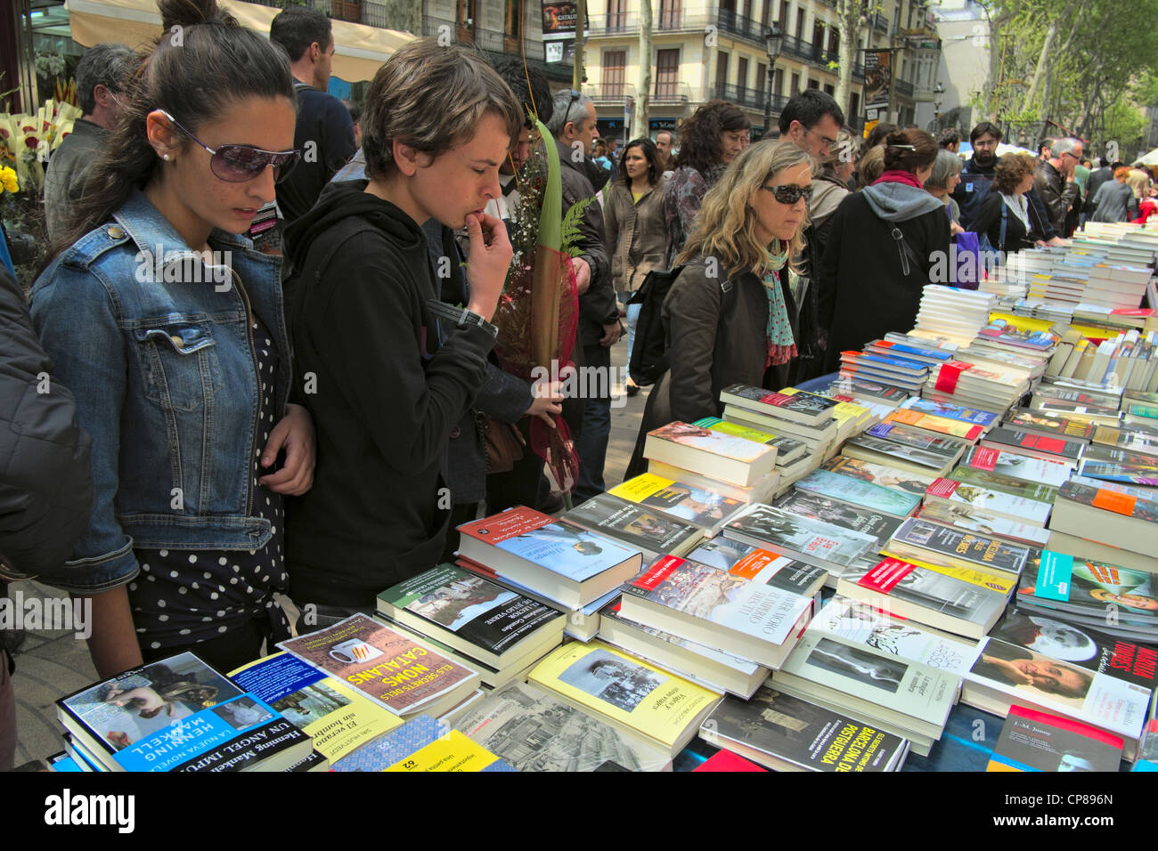 Book stall and customers on La Rambla in Barcelona on St. George Day, 2012. Stock Photo