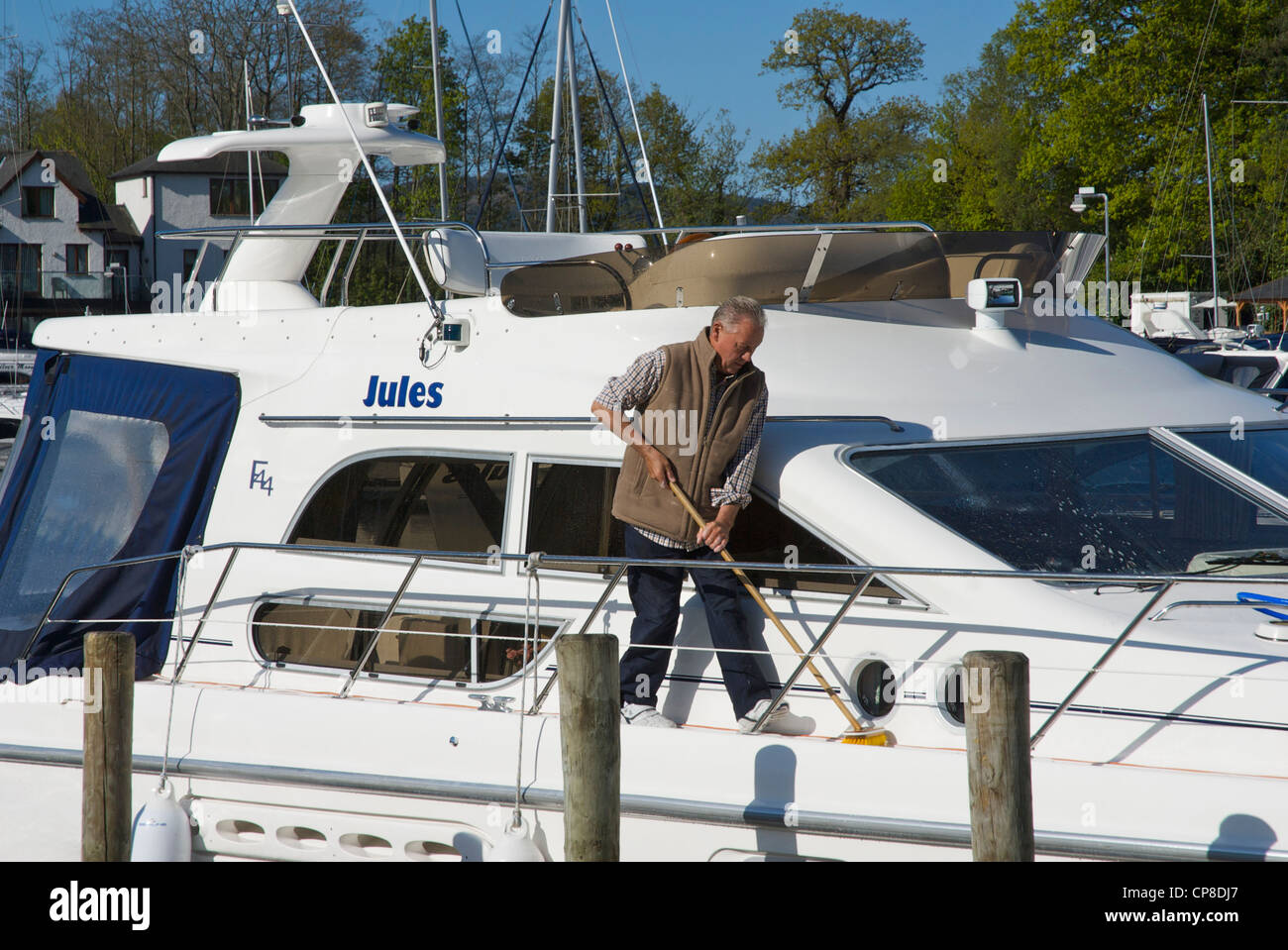 Man cleaning his boat in the Windermere Marina, near Bowness, Lake