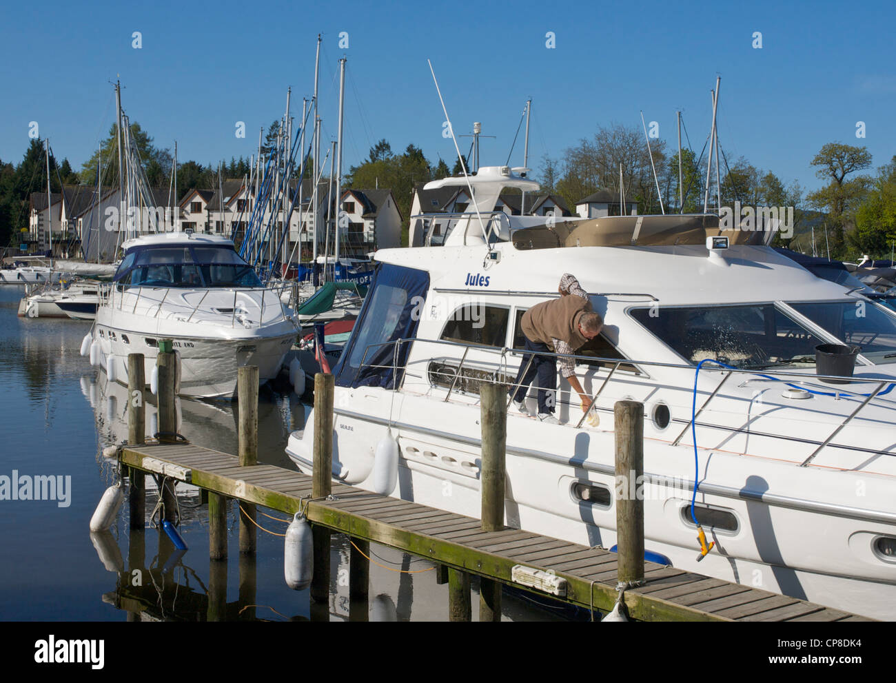 Man cleaning his boat in the Windermere Marina, near Bowness, Lake