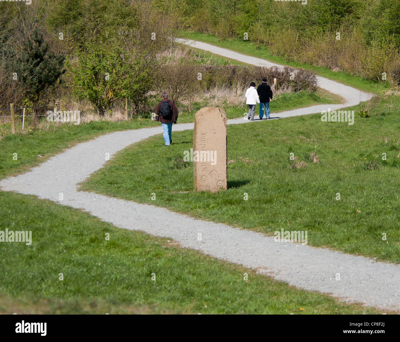 Walkers on pathway on Old Pale hill, Delamere Forest, Cheshire, with stone viewpoint marker Stock Photo