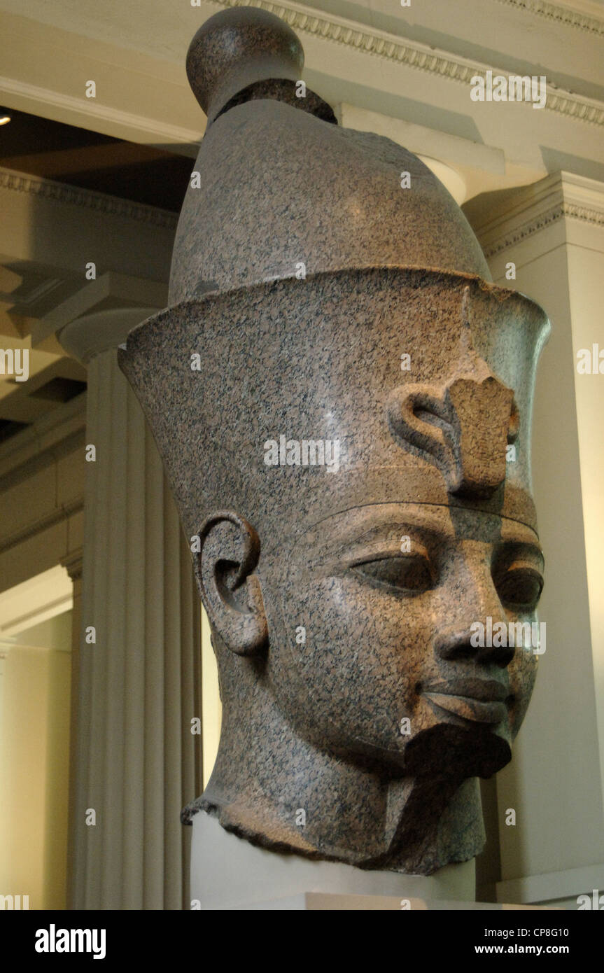 Head from monumental red granite statue of an egyptian king wearing the double crown. Probably Amenhotep III. Around 1390 BC. Stock Photo