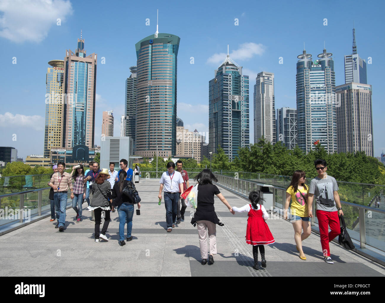 People walking on overhead walkway with skyline of skyscrapers in Lujiazui district of Pudong in Shanghai China Stock Photo