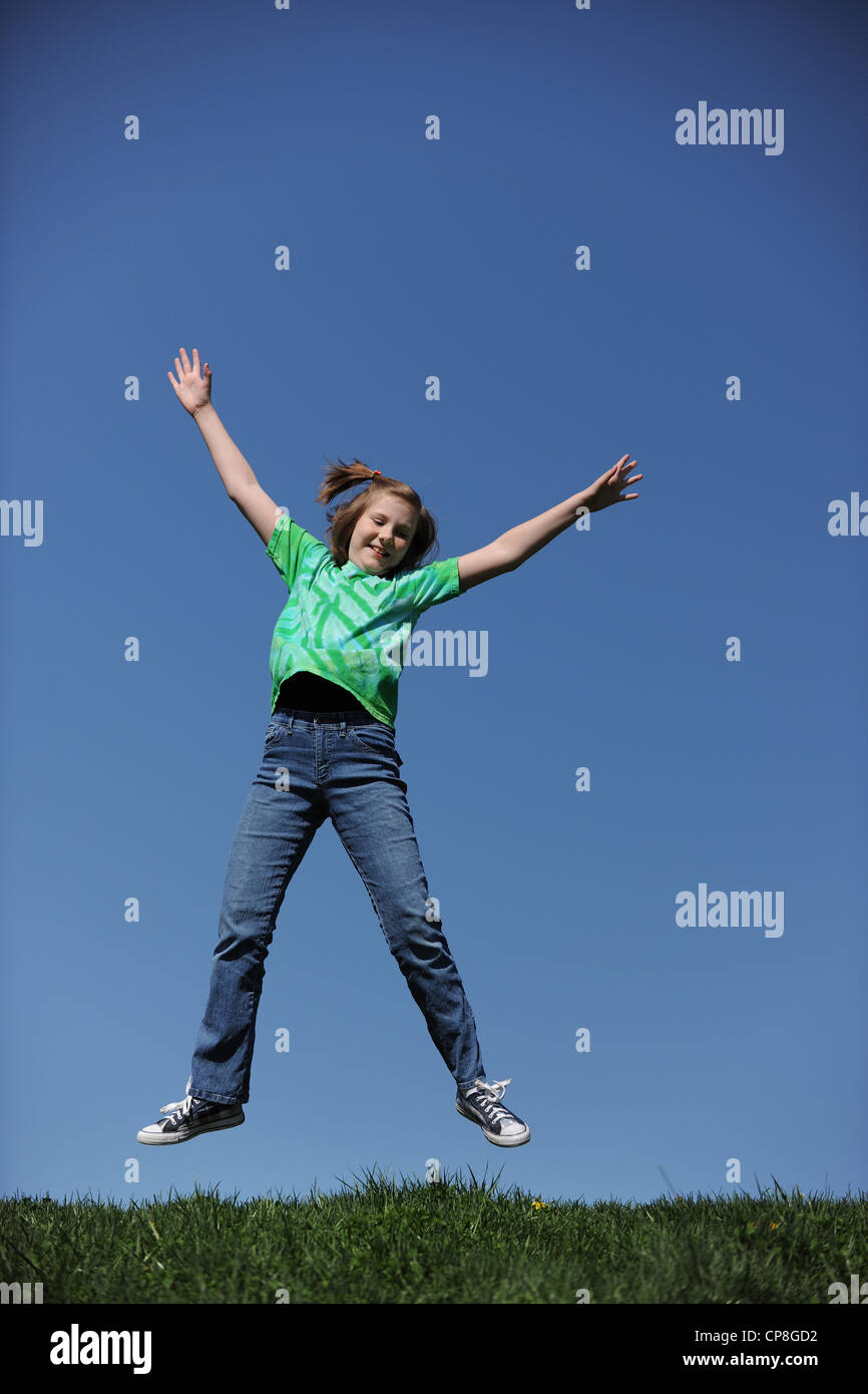 Young Girl Jumping on a sunny day against a blue sky Stock Photo - Alamy