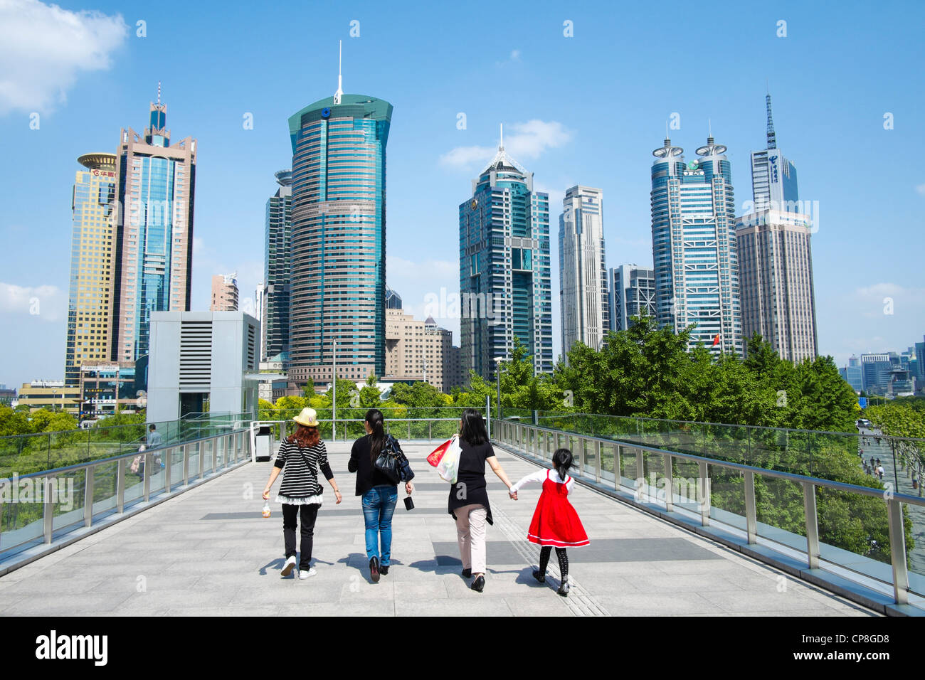 People walking on overhead walkway with skyline of skyscrapers in Lujiazui district of Pudong in Shanghai China Stock Photo